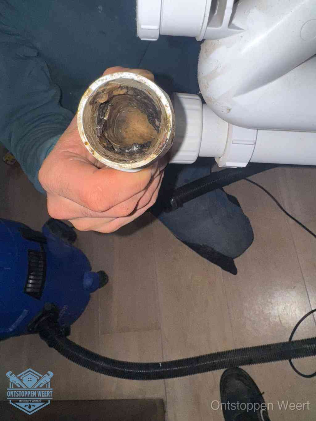 Een losgekoppeld afvoerbuisstuk dat van binnen volledig is dichtgeslibd, het gevolg van een verstopping te lang laten zitten in Weert