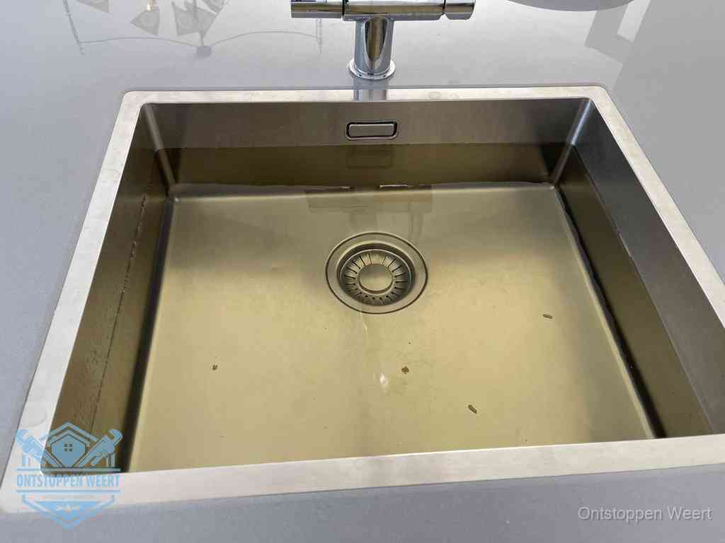 Stilstaand water in een rvs spoelbak dat niet wegloopt, een duidelijk signaal van een gootsteenverstopping in Weert