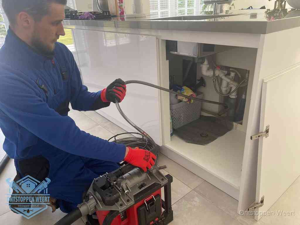 Een monteur reinigt de keukenafvoer grondig met een veermachine om terugkerende gootsteenverstoppingen te voorkomen in Weert